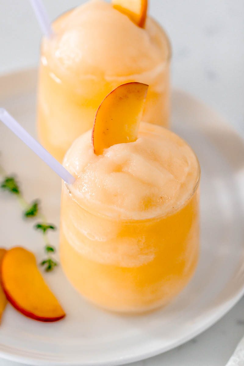 Frozen Peach Bellini Cocktail - Light, refreshing and super easy to make! This elegant cocktail slush will be a hit for any summer party.